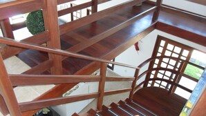 Un escalier en bois à plusieurs niveaux, doté d’une rampe, reliant les différents étages d’un immeuble.