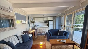 Un salon moderne avec un canapé, une table basse et une cuisine en arrière-plan.