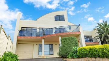 Stunning two-story residence with a curved roofline and balcony.