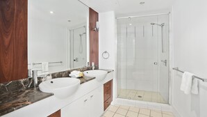 A modern bathroom with two sinks, a large mirror, and a glass-enclosed shower. - Apartment 2196 offers the perfect holiday adobe for small families and couples (Surfers Paradise)