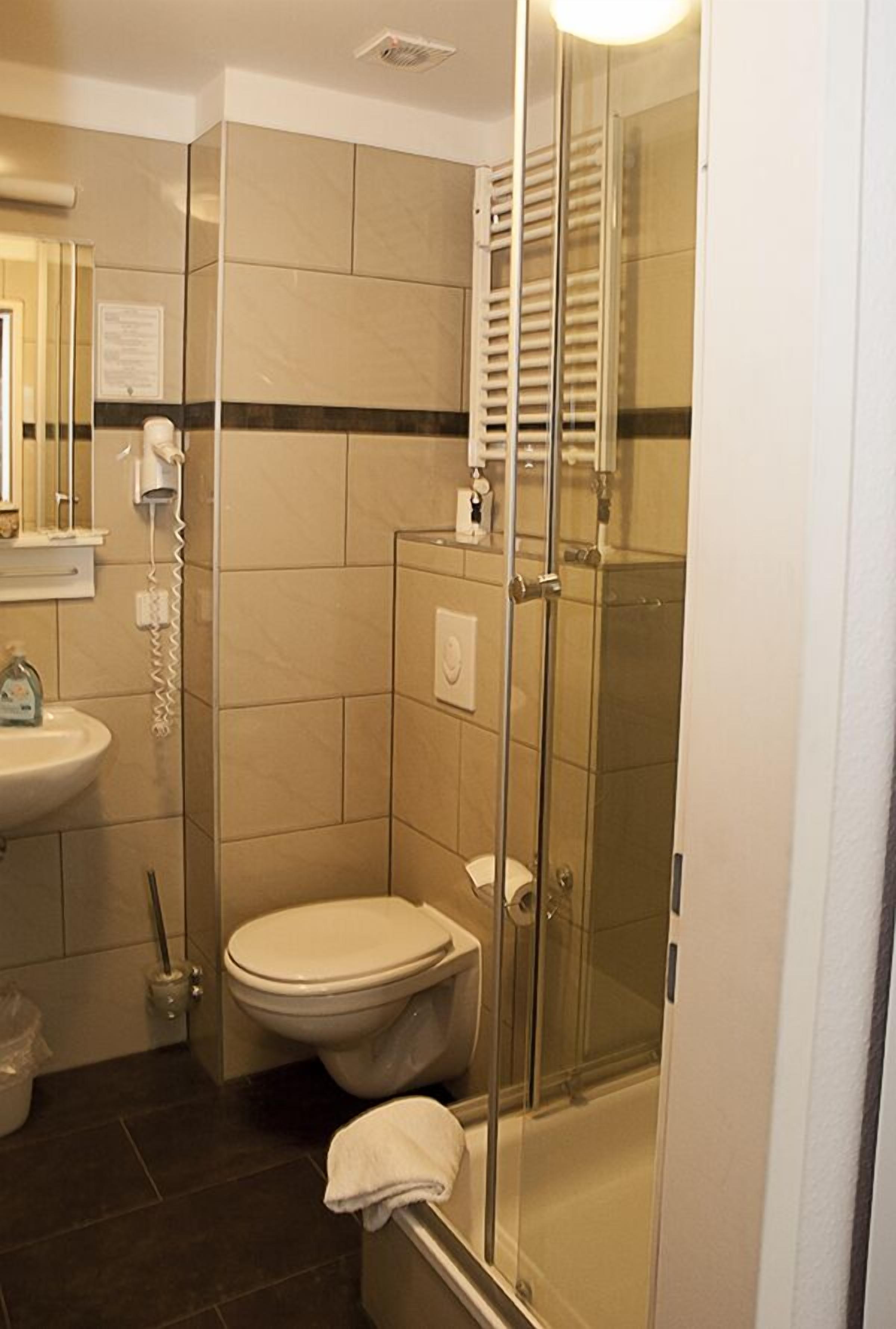 Tweepersoonskamer | Badkamer | Een douche, een haardroger, handdoeken