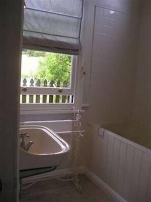 A bathroom with a window, a bathtub, and a radiator. - Rose Cottage B and B Quiet Getaway. Your own private space/ living room/bathroom (Rydal)