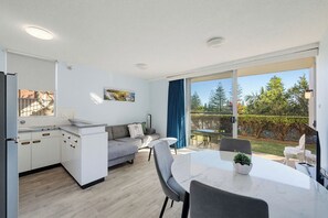 Eine moderne Küche mit weißen Schränken und einem Essbereich mit Tisch und Stühlen.