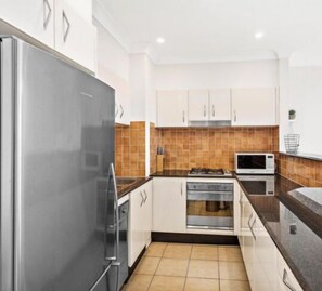 Enjoy cooking in this well-equipped kitchen with a refrigerator, microwave, and oven.