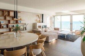 A modern living room with a dining area, a sofa set, and a fireplace.