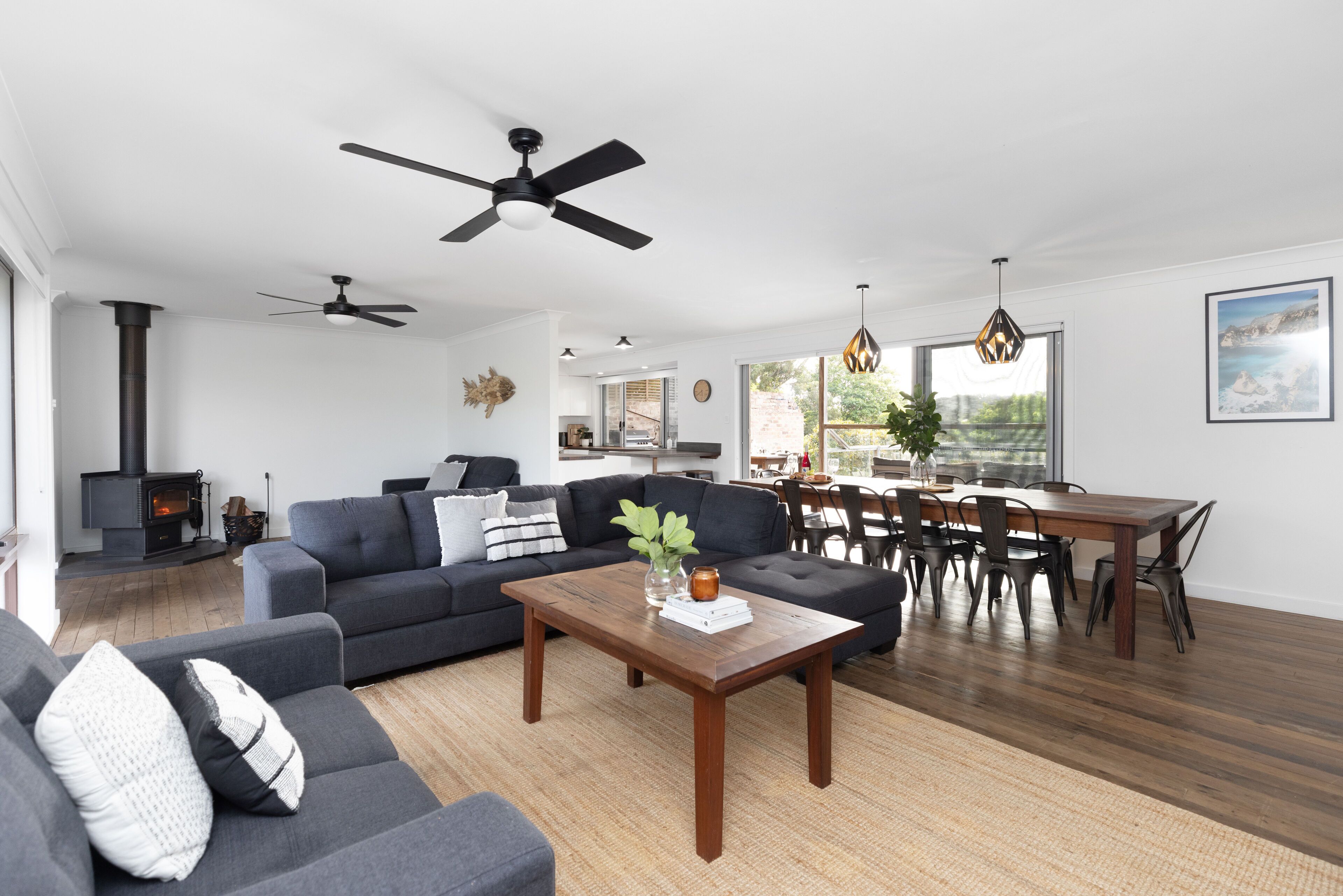A modern living room with a sofa, coffee table, and dining area.
