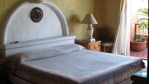 Una camera da letto con un letto grande, un comodino, una lampada e una finestra con tende.