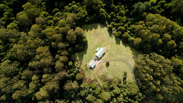Luchtbeeld van een landgoed met een groot gebouw, omringd door dicht bos.