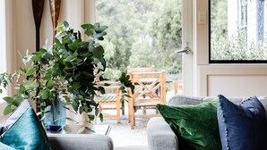 A room with two grey sofas, a potted plant, and a wooden table. - Naivasha Cottage with antique outdoor bath (REEDY MARSH)