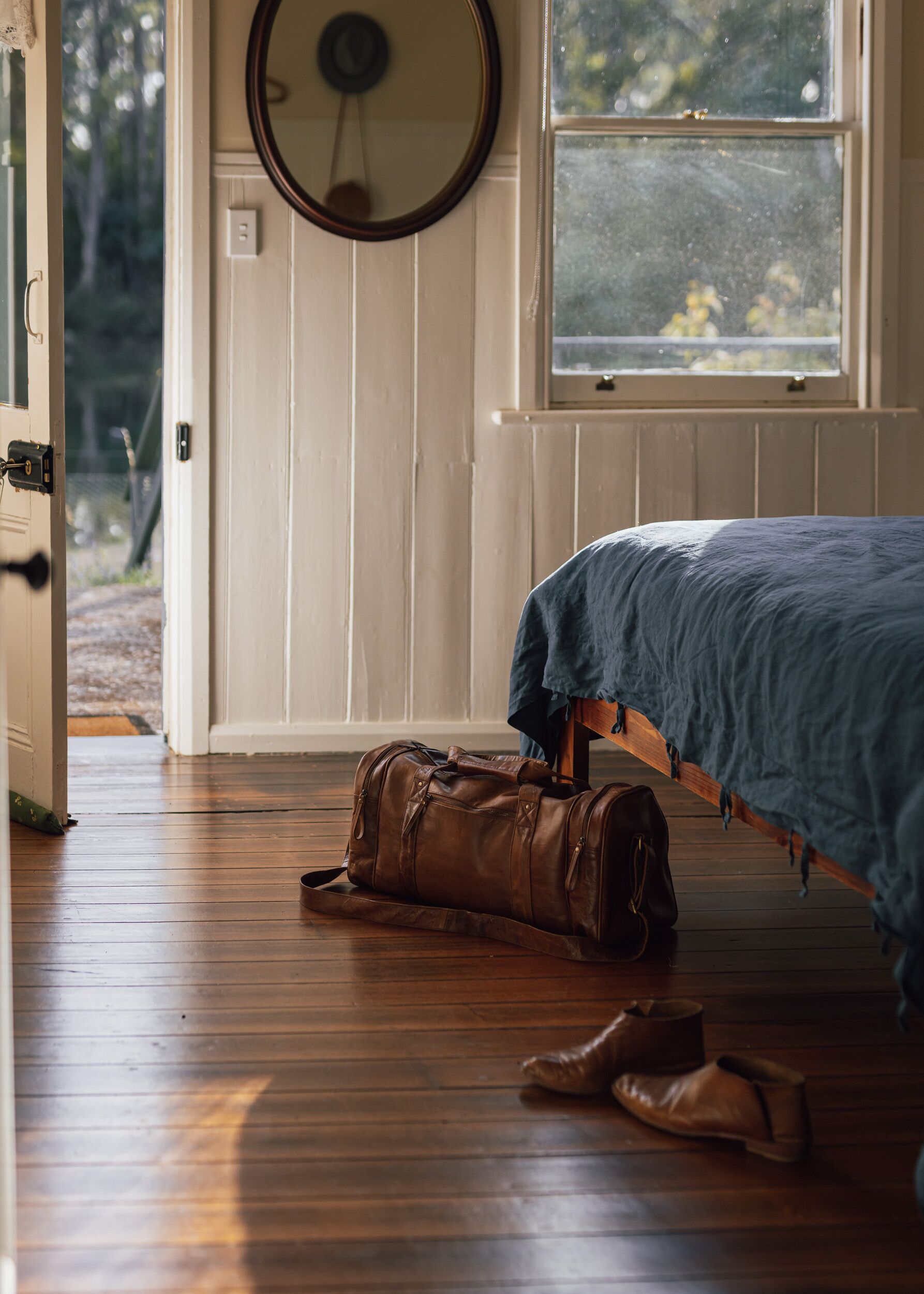 Een slaapkamer met een bed, een raam en een deur die naar buiten leidt.