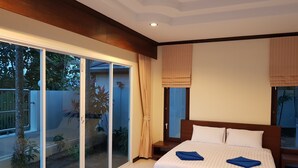 A bedroom with a large bed, sliding glass doors to a balcony, and a view of the outdoors. - Beautiful detached 5 bedroom, 4 bathroom Private Pool Villa, Kathu Phuket (Kathu)