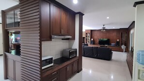 A modern kitchen with a built-in microwave, toaster, and oven. There is a water dispenser on the right and a ceiling fan above the kitchen area. - Beautiful detached 5 bedroom, 4 bathroom Private Pool Villa, Kathu Phuket (Kathu)