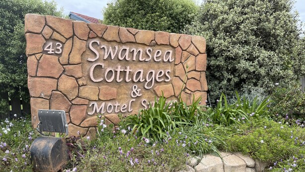 Señal de piedra para Swansea Cottages & Motel con el número 43.