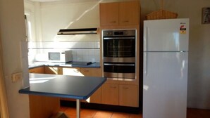 Una cocina compacta equipada con microondas, horno y refrigerador.