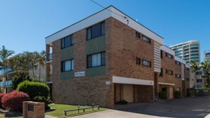 Un edificio de varios pisos de ladrillo con techo plano, ventanas amplias y un letrero que indica que es un motel.
