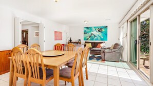 Un ampio soggiorno con zona pranzo, una grande finestra e un quadro appeso al muro.
