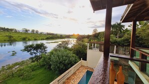Un balcón con vista a un río y vegetación.