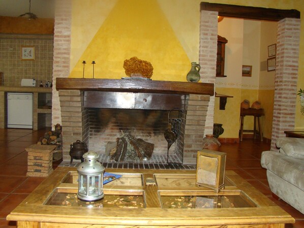 A living room with a fireplace, a wooden coffee table, and a sofa.