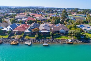 A residential area with houses, a dock, and a calm body of water.