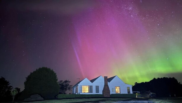 A house with two visible windows, a chimney, and a car parked in front. - Buttons Cottage underneath the Milky Way (Nietta)