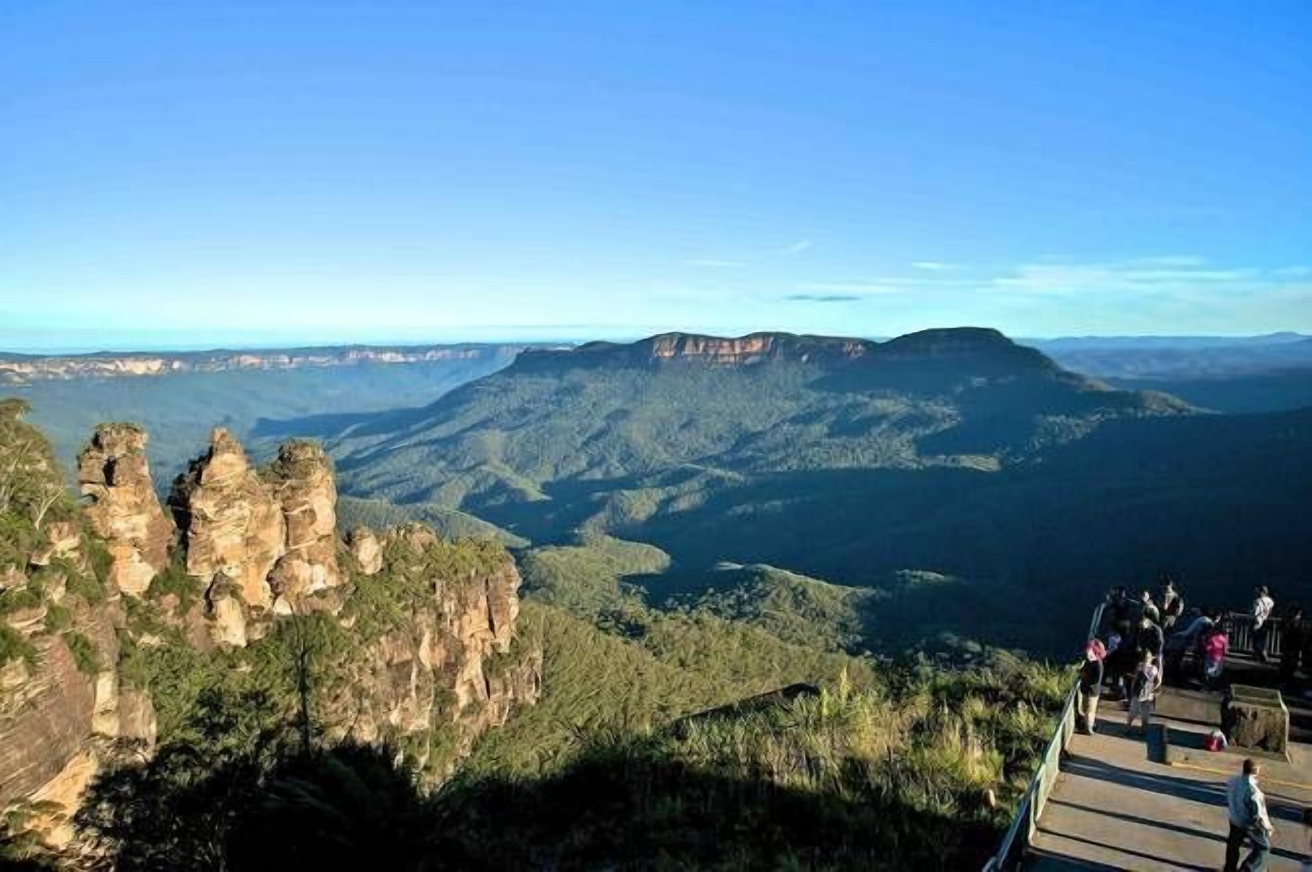 A scenic overlook with a view of layered rock formations and a valley below.