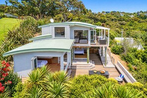 A two-story house with a deck, a bedroom, and a living area.