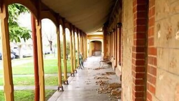 A covered walkway with a brick wall on one side and a grassy area on the other. - Stanley Cottage 2 bedroom (North Adelaide)