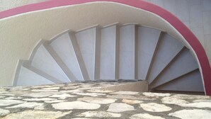 A stone-tiled floor leading to a white and pink arched staircase. - Apartment Iva - Great Vacation in the Center of Fazana, Istra (Croatia) (Fazana)