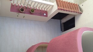 A bathroom with a stone wall, a pink bathtub, and a white sink with a decorative tile backsplash. - Apartment Iva - Great Vacation in the Center of Fazana, Istra (Croatia) (Fazana)