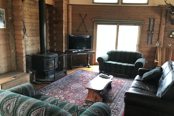 Large open lounge area with wood heater & split system cooler/heater