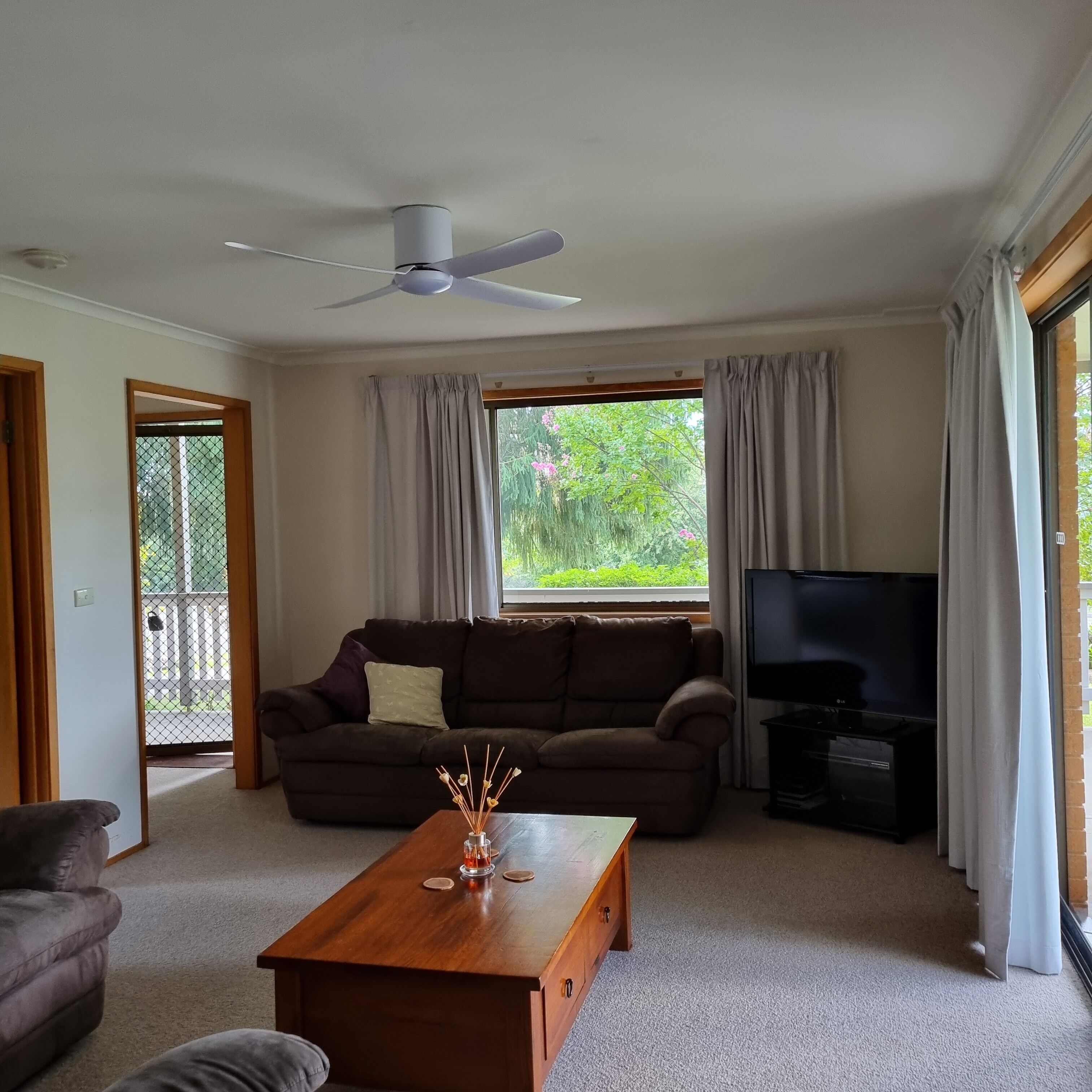 Lounge Room with TV and ceiling fan.