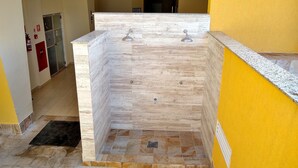A bathroom with a marble sink and a shower area. - Guaruja, Pitangueiras beach, flat with services. (Guarujá)