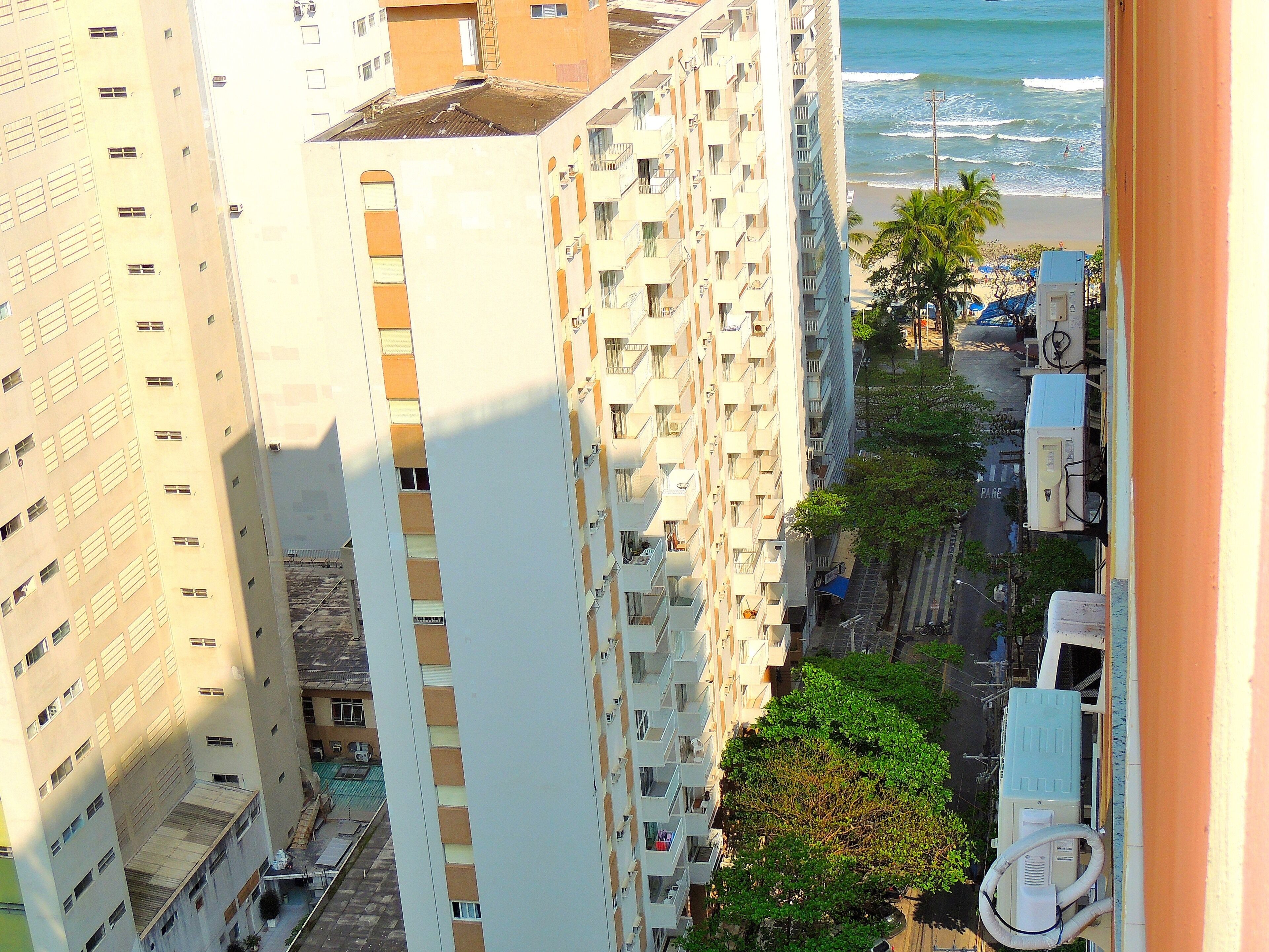 A high-rise building with multiple balconies overlooking a beach.