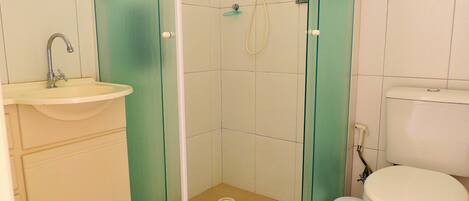 A bathroom with a sink, toilet, and shower enclosure.