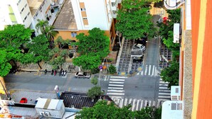An aerial view of a city street with buildings, trees, and vehicles. - Guaruja, Pitangueiras beach, flat with services. (Guarujá)