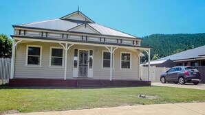 A single-story house with a gabled roof, a front porch, and a garage. - BLUE HILLS RISE: Bright (Bright)