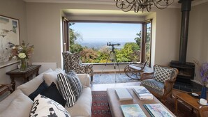 A cozy living room with a large window, a fireplace, and a telescope. - Boyanda At Ferny Creek - A wonderfully historic home with amazing views over the bays and sparkling lights. (Ferny Creek)