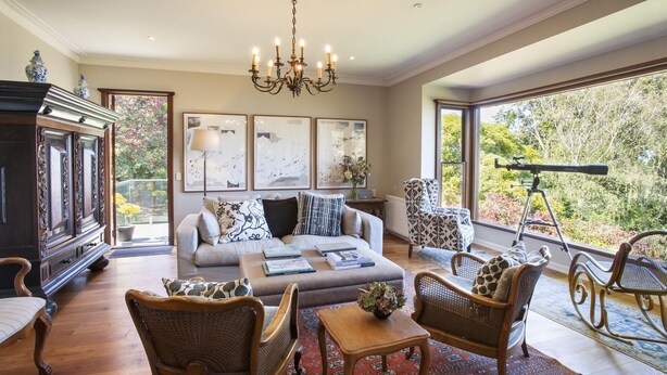 A spacious living room with a large sofa, two rocking chairs, a wooden coffee table, and a telescope on a balcony. - Boyanda At Ferny Creek - A wonderfully historic home with amazing views over the bays and sparkling lights. (Ferny Creek)