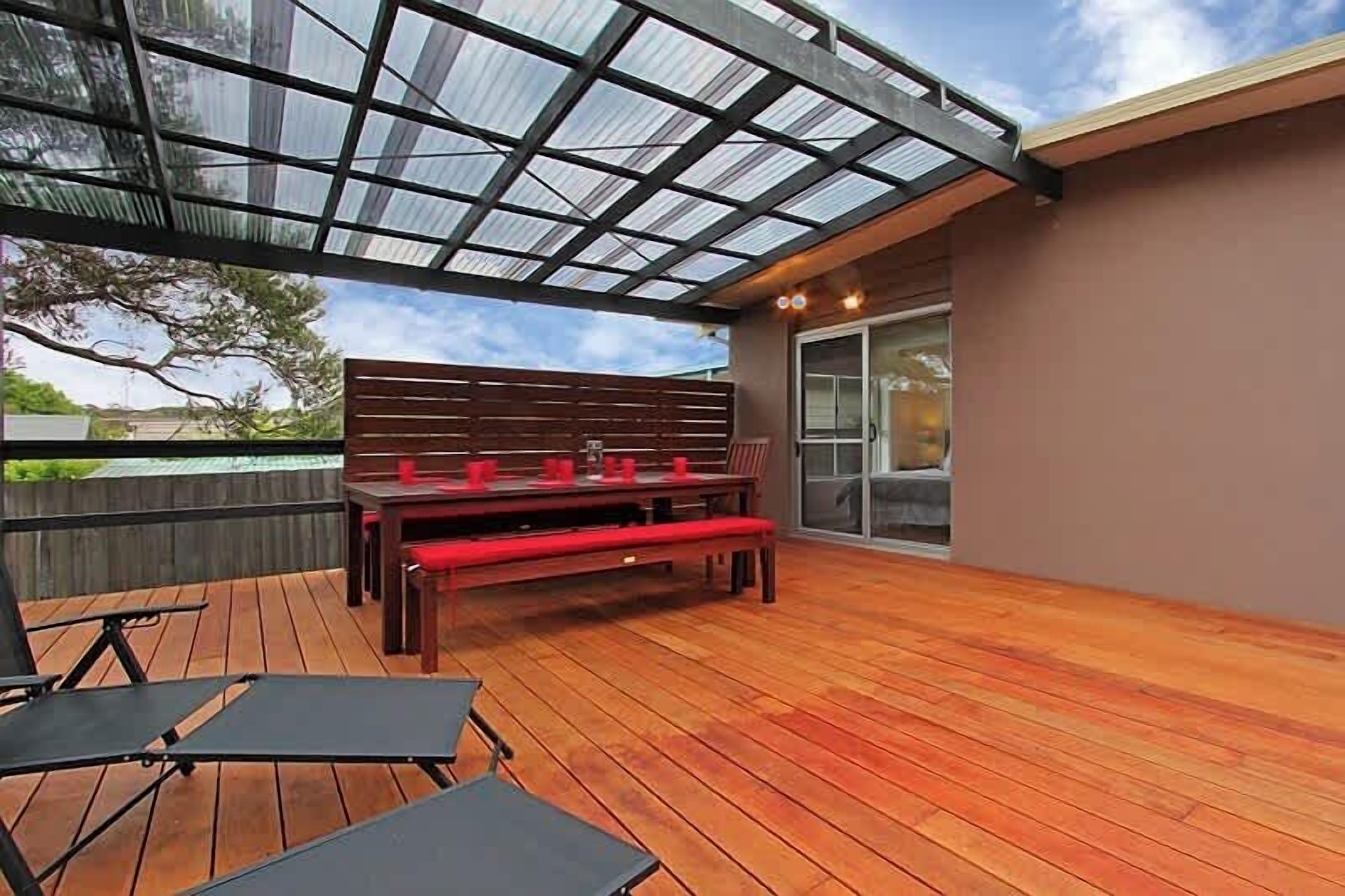 Une terrasse extérieure avec une plateforme en bois, un banc et une table.