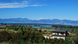Ein modernes Haus mit Blick auf Berge und einen See.