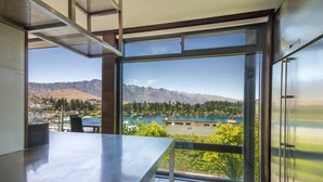 Une cuisine moderne dotée d’une grande fenêtre donnant sur un paysage montagneux et un lac.