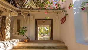 A staircase leading to a pool area, surrounded by white walls and potted plants.