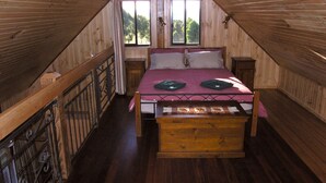 A wooden attic bedroom with a bed, a window, and a view of trees. - 2 Night Accommodation Package (GEMBROOK)