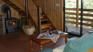 A cozy room with a fireplace, wooden staircase, and a dining area with a table set for two. - 2 Night Accommodation Package (GEMBROOK)