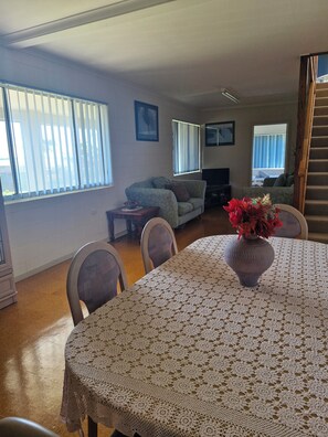Una sala de estar con una mesa de comedor, sillas, un sofá y una chimenea.