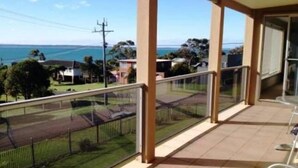 A balcony with a view of the sea and houses.