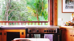 Una cucina con un grande fornello, mobili in legno e vista su un verdeggiante paesaggio.