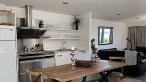 A modern kitchen with white cabinetry, a stainless steel range, and a built-in wine rack. - Relax, unwind and enjoy the views from this unbeatable lakeside location. (Two Mile Bay (2 Mile Bay))