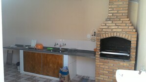 Una cocina con horno de ladrillo integrado, un lavabo y un armario de madera.