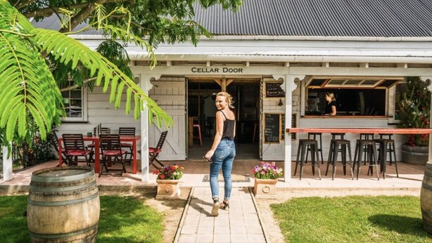 Een gebouw met opschrift 'CELLAR DOOR', met terras en een bar.